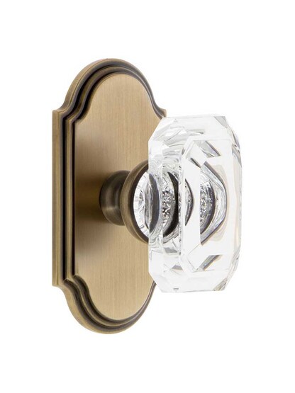 Grandeur Arc Rosette Door Set with Clear Crystal-Glass Baguette Knobs in Antique Brass.